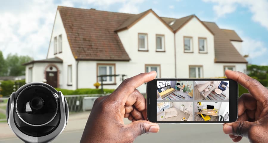Man holding phone and viewing footage from surveillance cameras